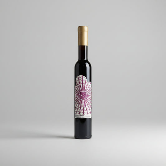 Wine bottle with a decorative label in a white frame on a wooden surface